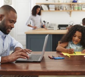 dad on laptop and daughter playing