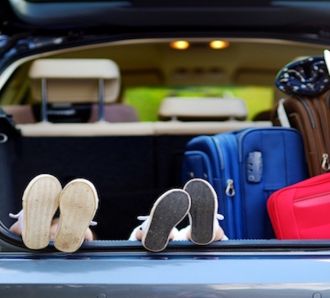 kids feet in car ready for road trip packed luggage