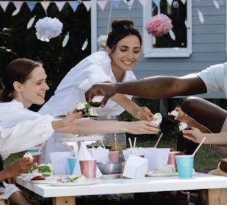 A diverse family group enjoy a party outdoors