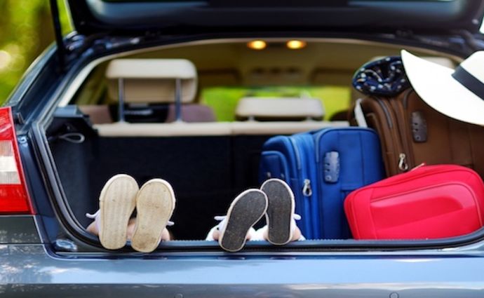 kids feet in car ready for road trip packed luggage