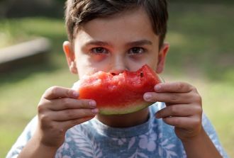 young boy eating watermelon family day out blog encouraging healthy eating in children