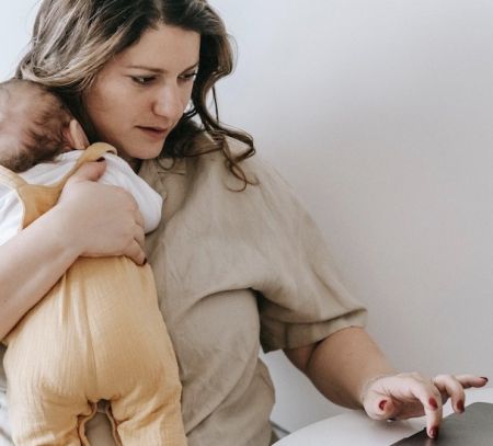 mother working at computer laptop with baby working from home