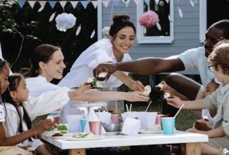 A diverse family group enjoy a party outdoors