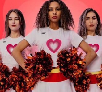 Cheerleaders in heart uniforms holding pom-poms