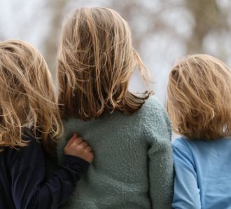 siblings children back of heads hugging