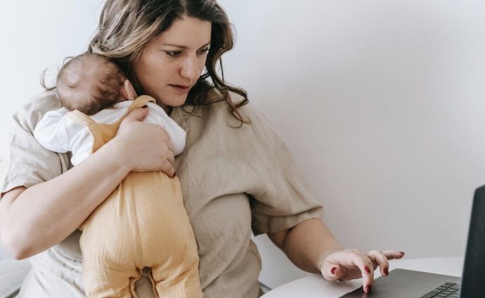 mother working at computer laptop with baby working from home
