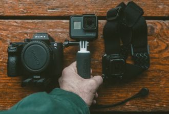 a hand holding a go-pro camera and equipment