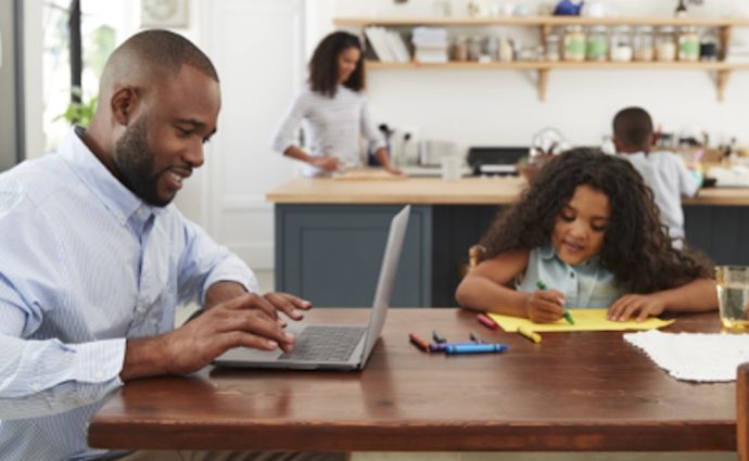dad on laptop and daughter playing