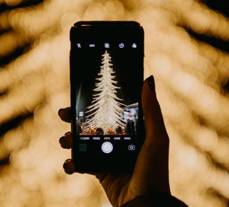 a woman takes a photo of a xmas tree