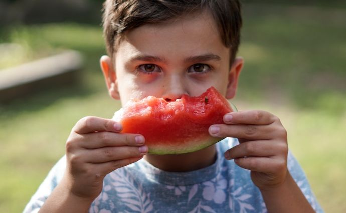 young boy eating watermelon family day out blog encouraging healthy eating in children