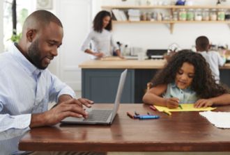 dad on laptop and daughter playing