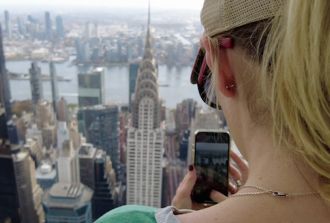 A lady takes a photo of the Chrysler building from Summit One